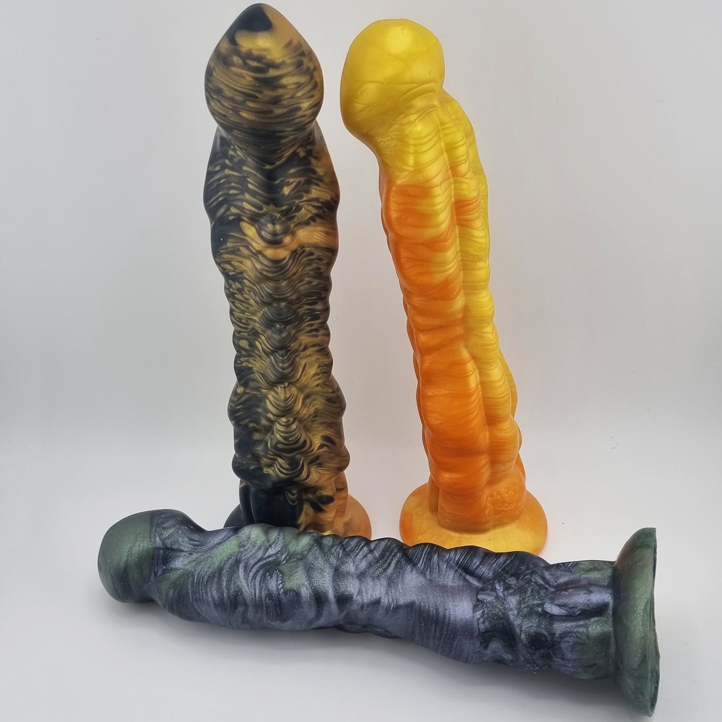 Three Brat Breakers Draggin' dildo . Black and gold. Yellow and orange. Green, purple and black