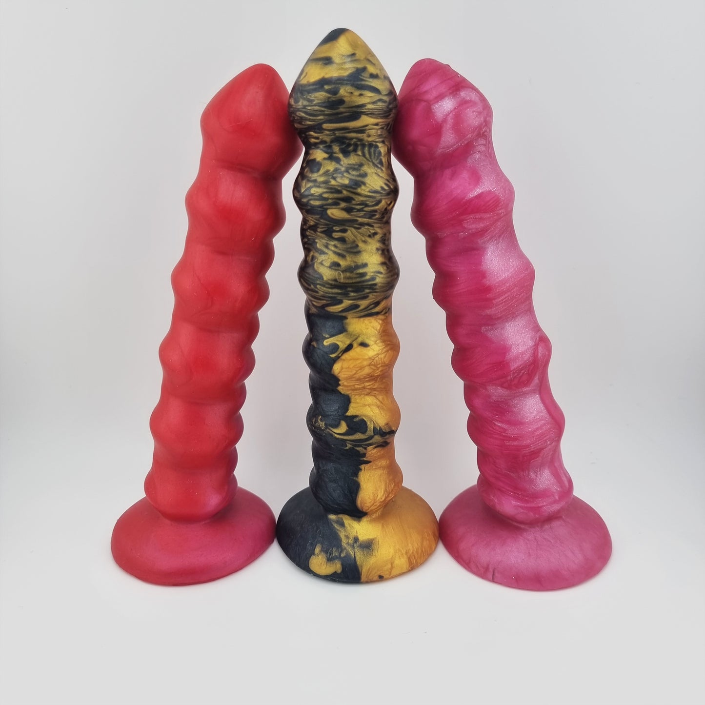 Three Brat Breakers Bubblez dildos. Black and gold. Pink and red.